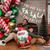 Man and child sitting in front of a decorated fireplace with Christmas decorations and balloons.